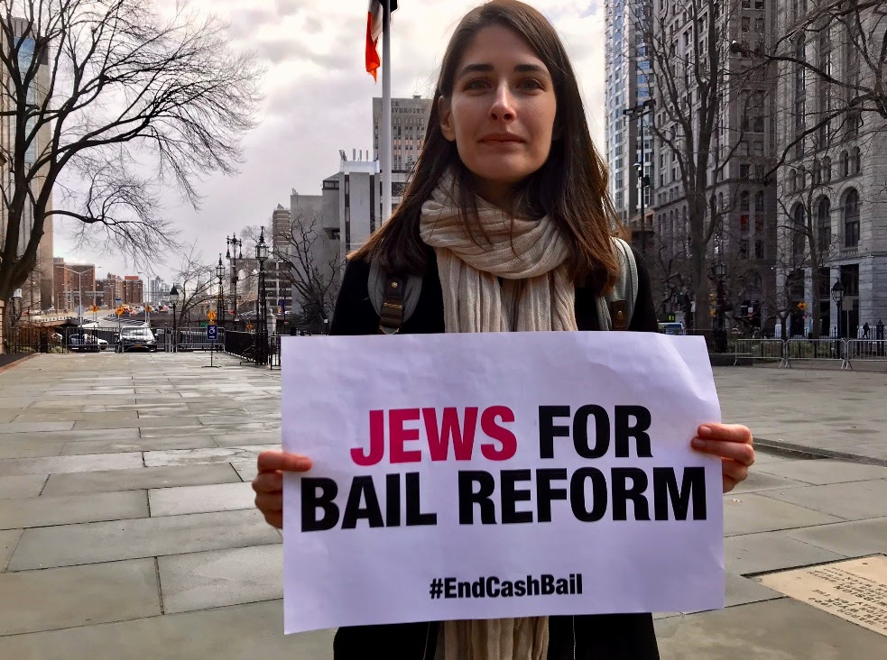 Elena holds sign that says Jews for Bail Reform